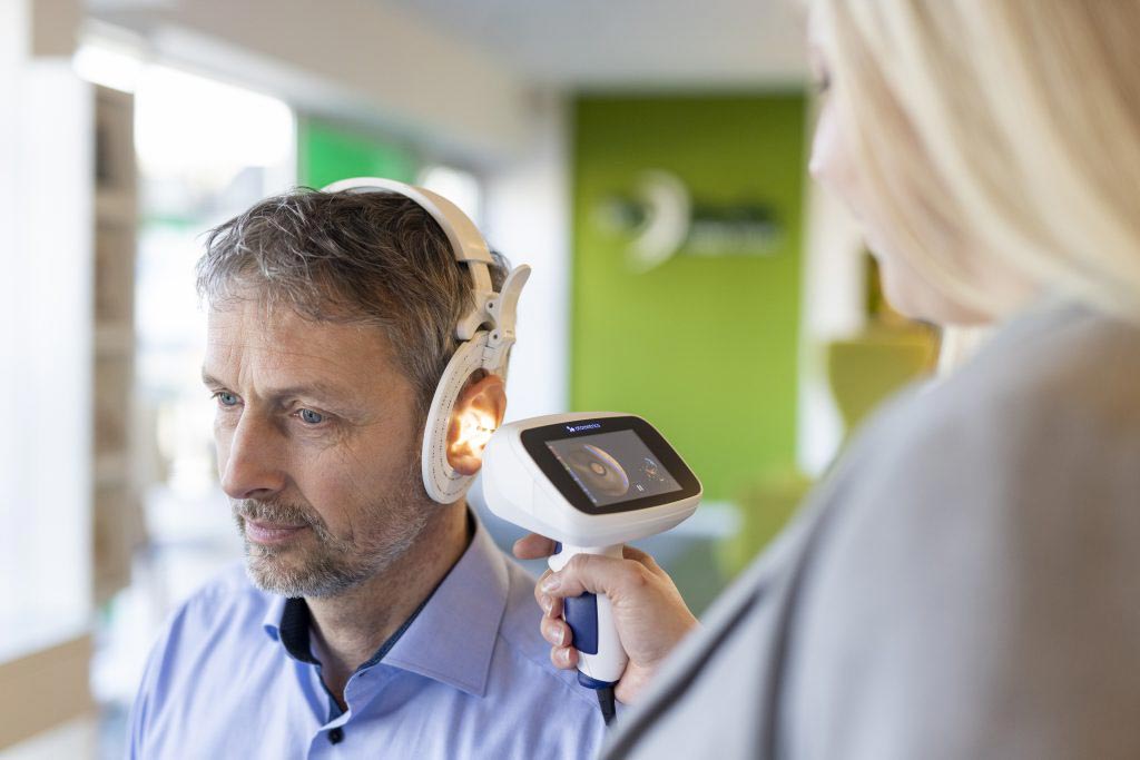 Mitarbeiterin nimmt einen 3D-Ohrdruck mit dem Ohrscanner