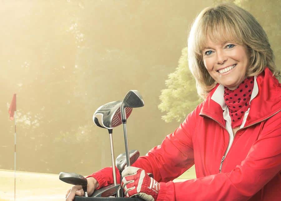 Frau in roter Jacken und mit Golfschläger